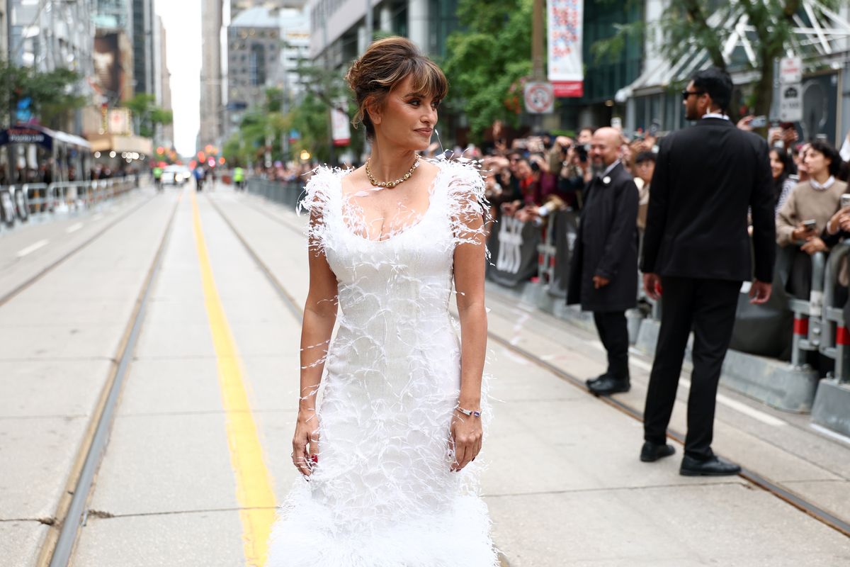 The actress showed off the gown’s figure-hugging silhouette and cascading feather details as she posed on the TIFF red carpet.