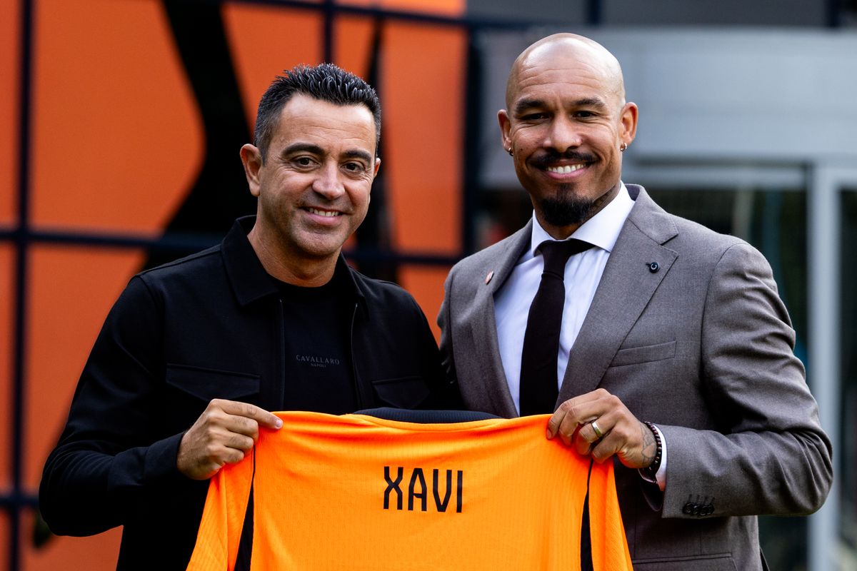 Xavi Hernandez alongsided the KNVB director of football Nigel de Jong