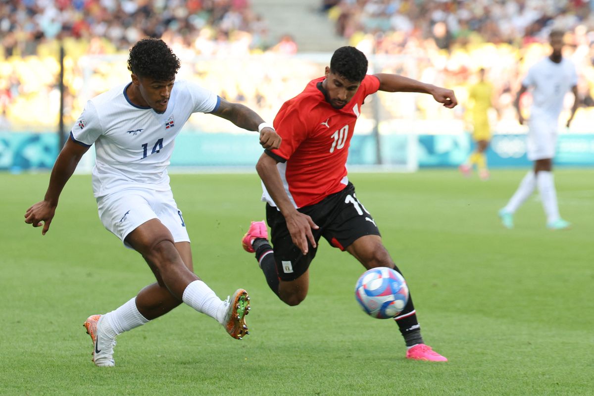 Dominican Republic's midfielder #14 Omar De La Cruz is marked by Egypt's midfielder #10 Ibrahim Adel during the men's group C football match between Egypt and the Dominican Republic during the Paris 2024 Olympic Games at the La Beaujoire Stadium in Nantes on July 24, 2024. 