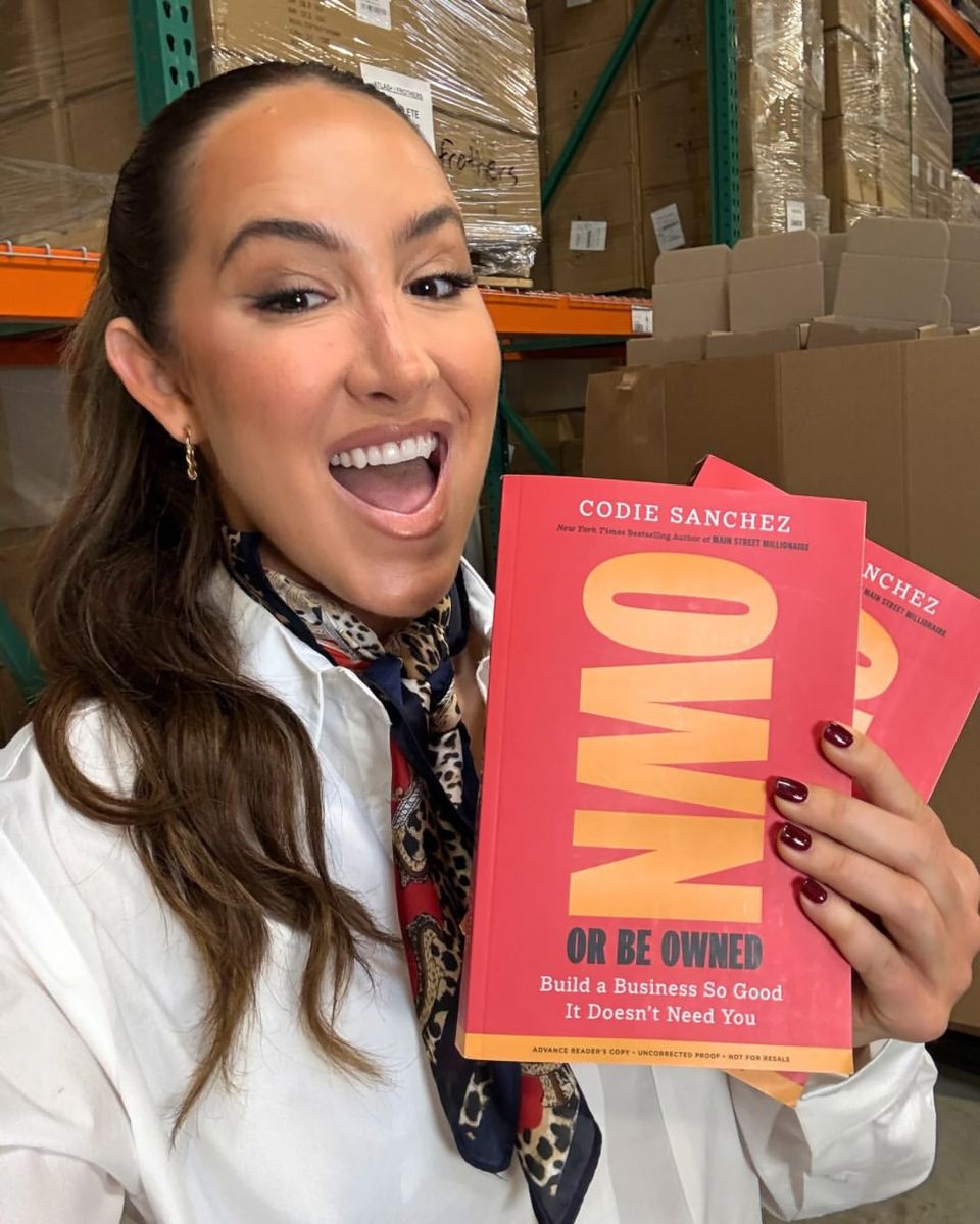 Sanchez with copies of her latest book, 'Own or Be Owned: Build a Business So Good It Doesn’t Need You.'