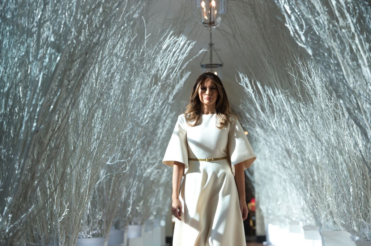 First Lady Melania Trump walks through Christmas decorations in the East Wing as she tours holiday decorations at the White House in 2017