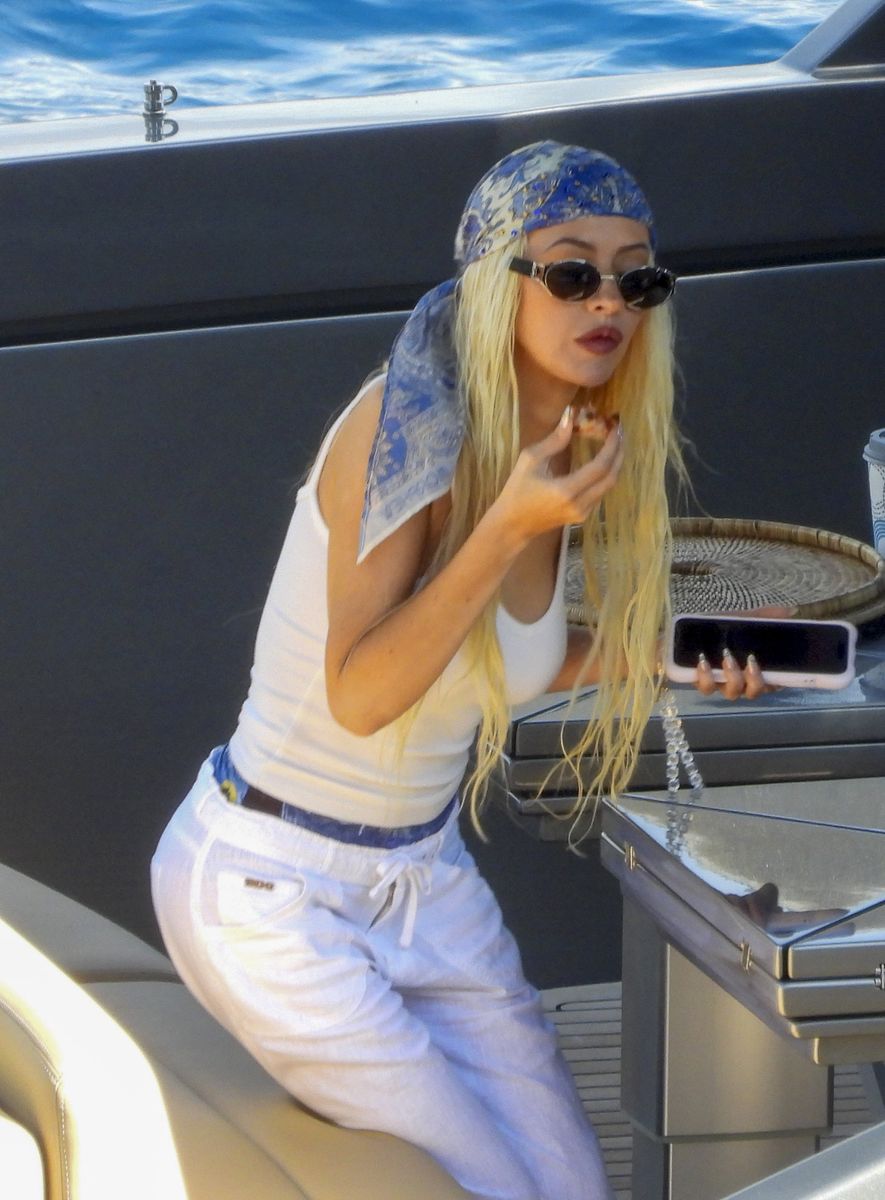 Christina Aguilera and her partner Matthew Rutler packed on the PDA during a sun-soaked day in Portofino, strolling along the shore and stopping by the Verga 1947 Boutique before boarding a boat to a larger yacht to relax, sunbathe, sip drinks, and share kisses, with the singer wearing a cream sleeveless top, white linen trousers, white flip-flops, rounded tinted sunglasses, and a blue-and-white head bandana.***Christina Aguilera y su pareja Matthew Rutler mostraron su afecto durante un día soleado en Portofino, paseando por la costa y visitando la boutique Verga 1947 antes de abordar una embarcación hacia un yate más grande para relajarse, tomar el sol, beber algo y besarse, vistiendo la cantante una parte superior sin mangas color crema, pantalones de lino blancos, chanclas blancas, gafas de sol redondas tintadas y una bandana azul y blanca en la cabeza.
Byline: COBRA TEAM / BACKGRID / GROSBY GROUP