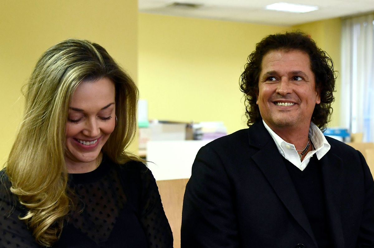 Colombian singer Carlos Vives (R) sits next to his wife Claudia Elena Vasquez in a court.