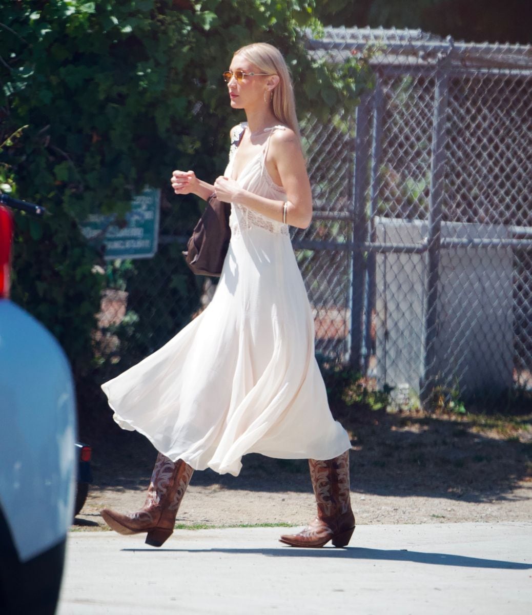 Bella wore her signature cowboy boots and a summery white dress, accessorized with a brown Valentino bag. 
