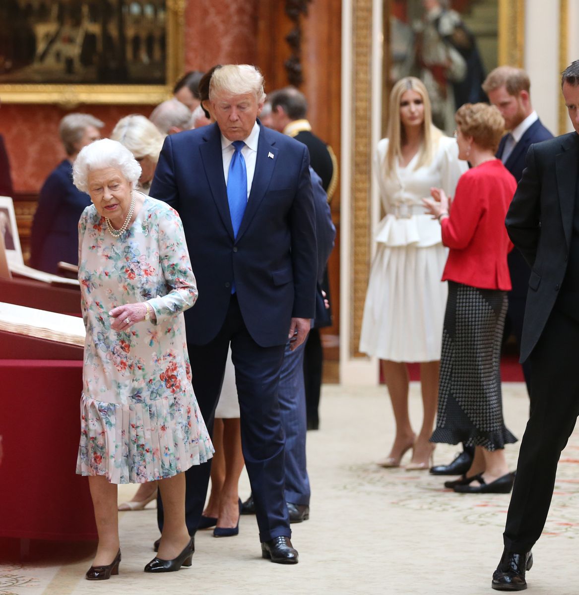 Queen Elizabeth II (L) and US President Donald Trump (2nd L) view American items in the Royal collection while Ivanka Trump (4th R) daughter of US President Donald Trump, speaks with Prince Harry, Duke of Sussex (2nd R) at Buckingham Palace