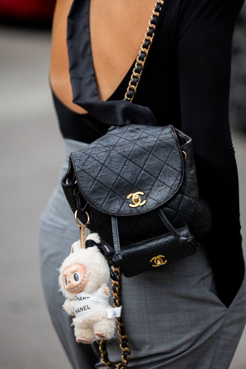 A guest wears black Chanel backpack with Wakuku puppet outside Marimekko during Copenhagen Fashion Week day four on August 07, 2025 in Copenhagen, Denmark. (Photo by Christian Vierig/Getty Images)
