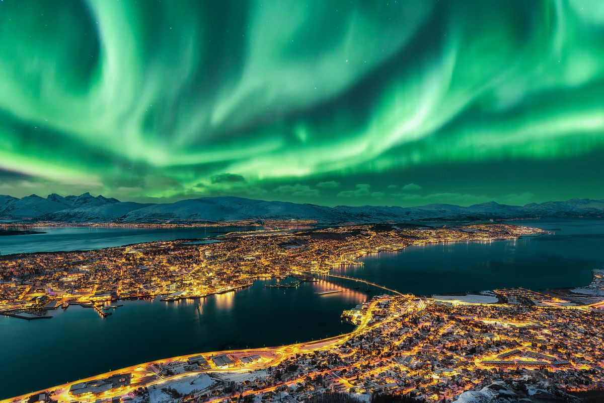 Aurora Borealis dancing over Tromso Urban Skyline.