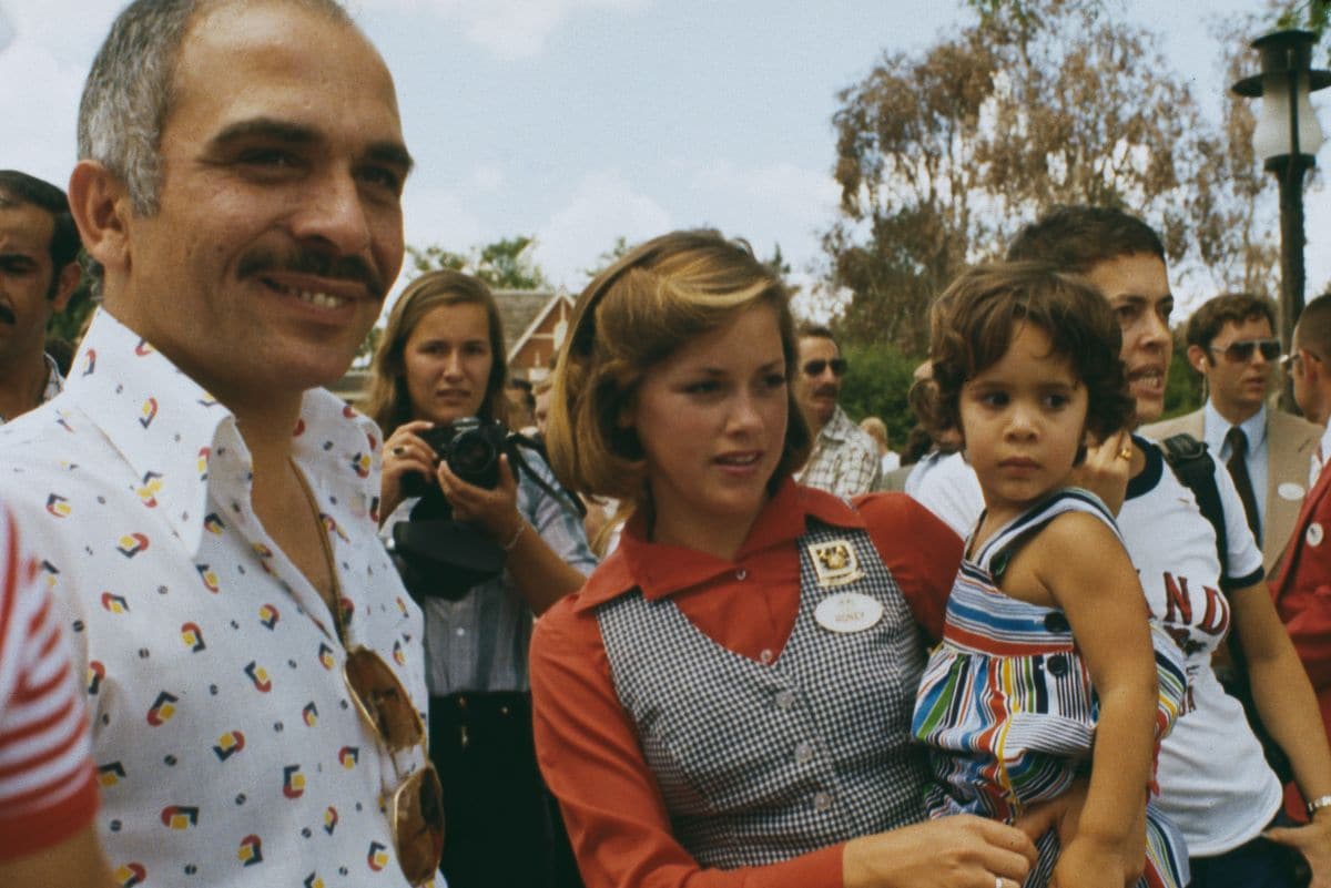 King Hussein of Jordan (1935 - 1999) visiting Walt Disney World as tour guide Honey Rex (centre) carries his daughter, Princess Abir, in Orlando, Florida, May 7th 1977. (Photo by UPI/Bettmann Archive/Getty Images)