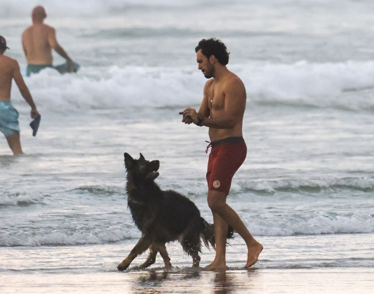 Joaquim Valente on the beach playing with their dog