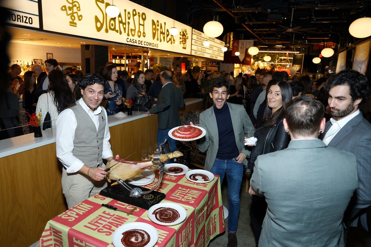 A worker displays ham hock dishes at the Jose Andres and Family in Spain D+ Series reception at Mercado Little Spain