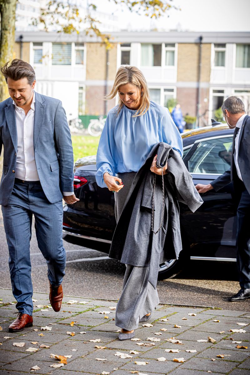 Paired with a blue blouse, grey heels, and a matching purse, Máxima’s look balanced professionalism with approachability.