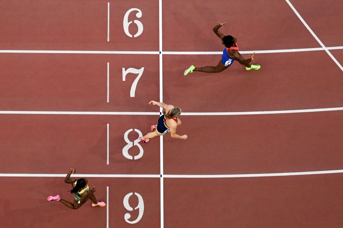 Dominican Republic's Marileidy Paulino (top) celebrates her victory ahead of Norway's Henriette Jaeger (C) and Jamaica's Nickisha Pryce in the women's 400m final 