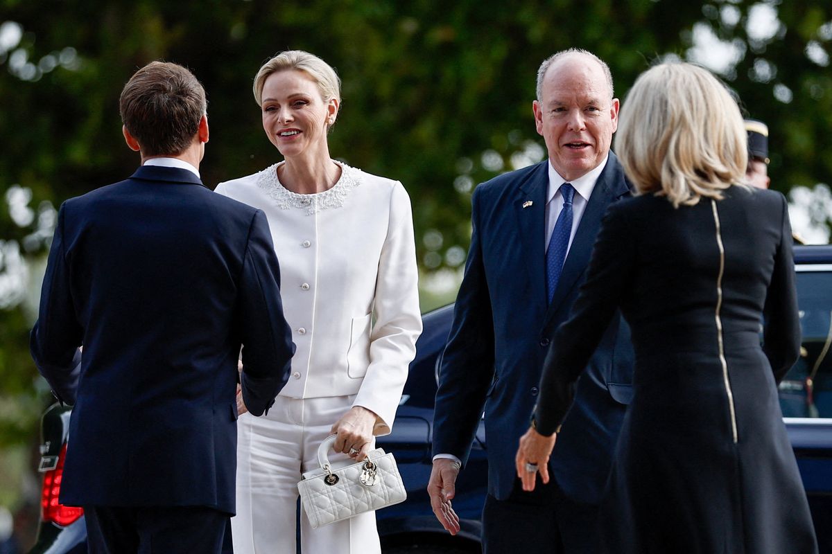 French President Emmanuel Macron (L) and his wife Brigitte Macron (R) welcome Prince Albert II (2nd R) and Princess Charlene (2nd L) of Monaco