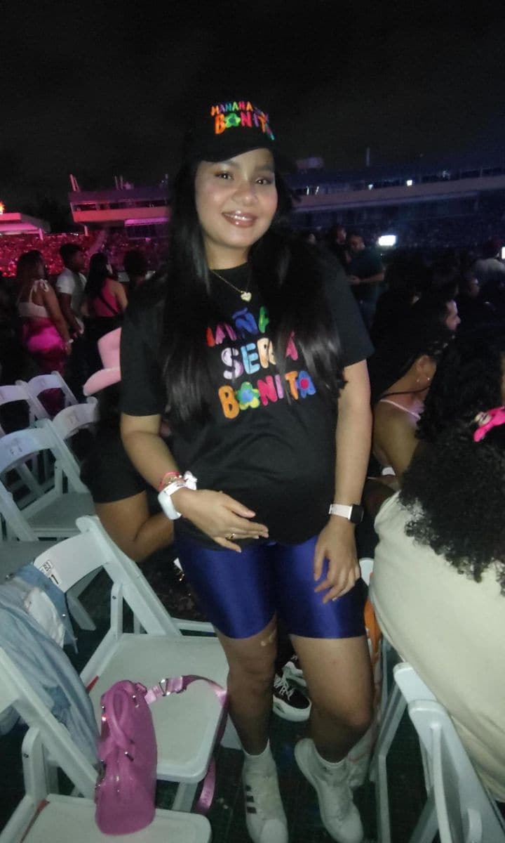Karol G helps a fan with her gender reveal during the singer’s Dominican Republic concert