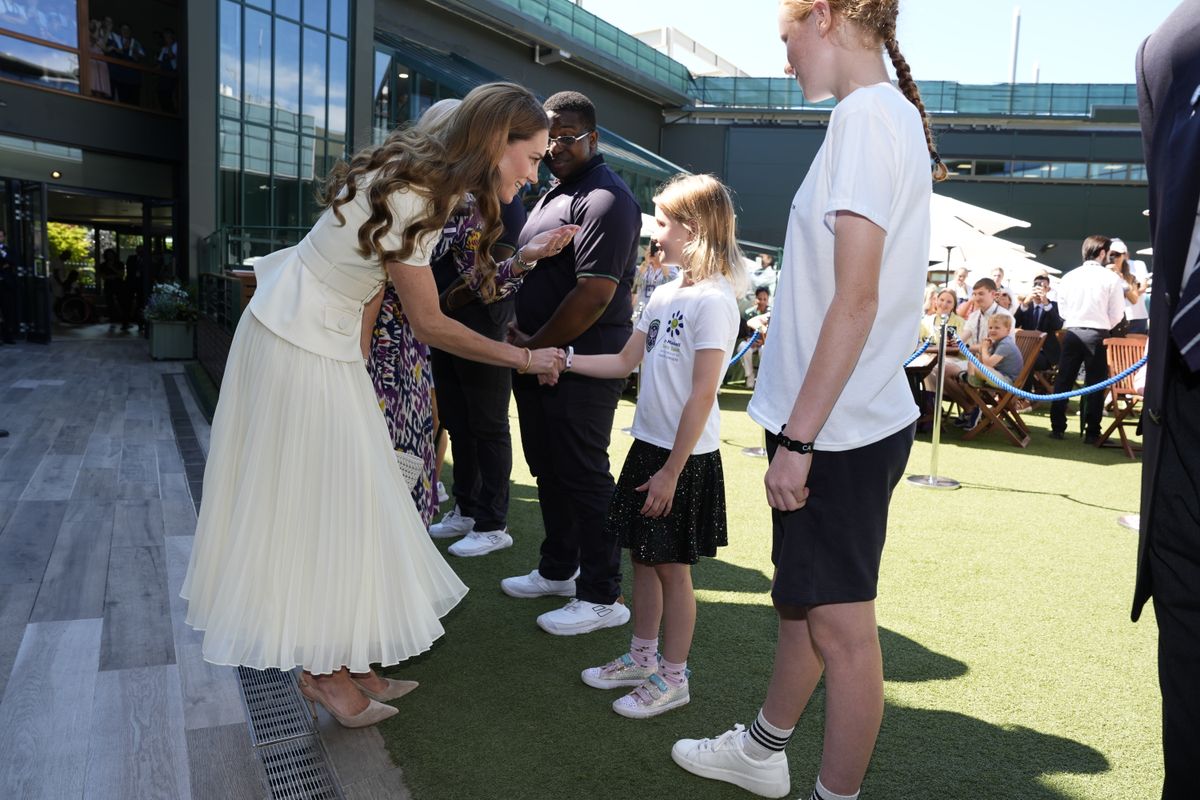 LONDON, ENGLAND - JULY 12: Catherine, Princess of Wales meeting Lydia Lowe, eight, from the Dan Maskell Tennis Trust, as she arrives to attend the Ladies' Singles Final during day thirteen of The Championships Wimbledon 2025 at All England Lawn Tennis and Croquet Club on July 12, 2025 in London, England. (Photo by Jordan Pettitt - WPA Pool/Getty Images)