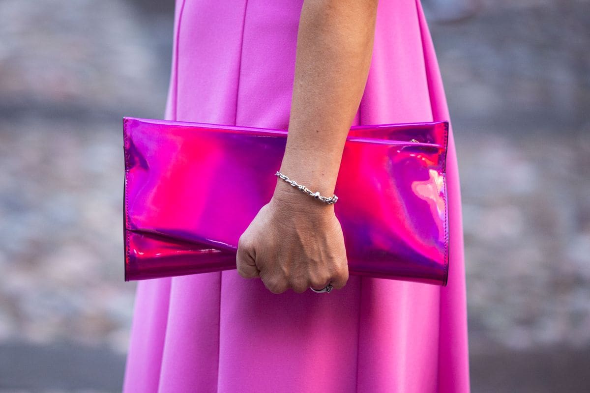 Crown Princess Victoria of Sweden paired the look with the Christian Louboutin 'Loubitwist' clutch in matching fuchsia.