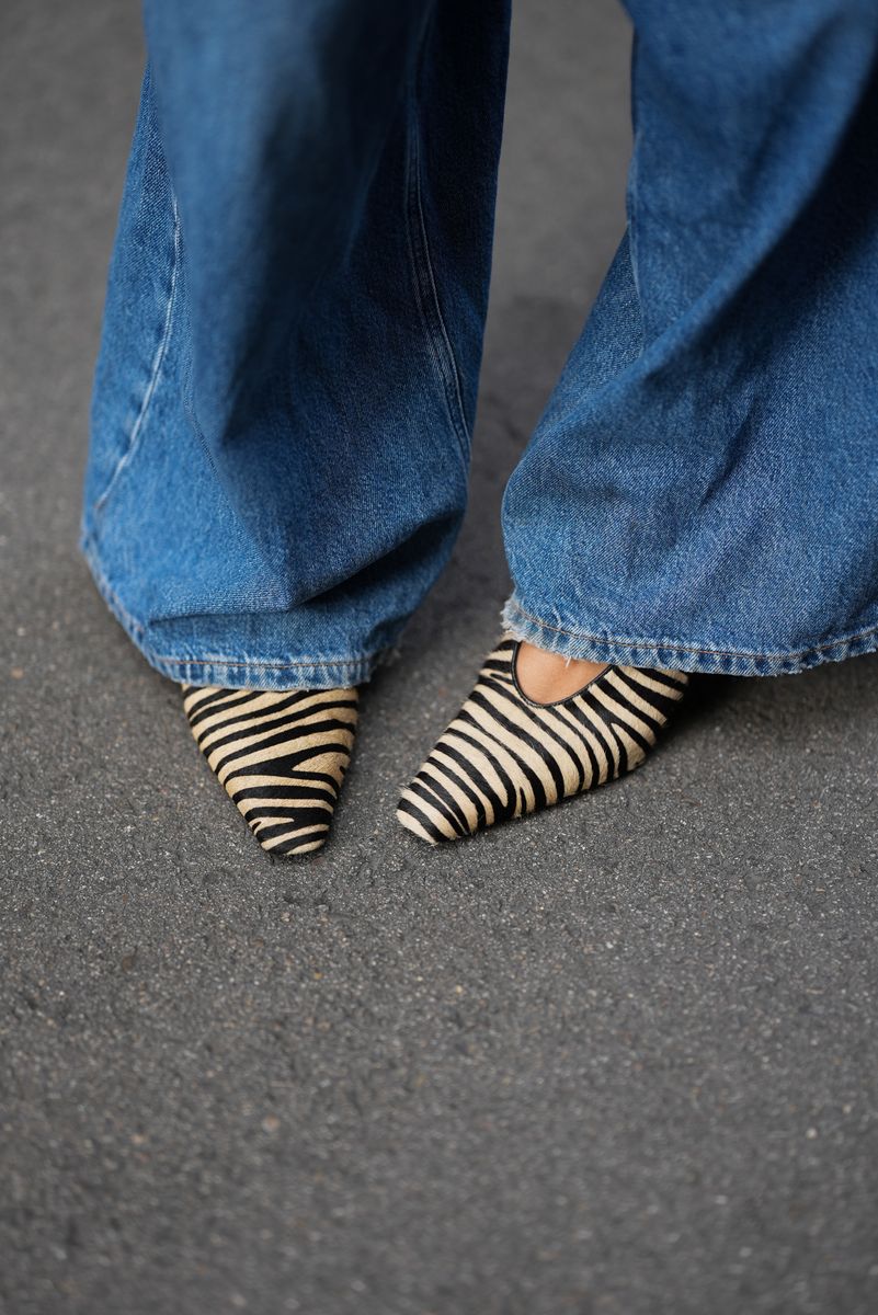 Amanda Mahle is seen wearing blue wide-leg denim jeans from PNTS; zebra print pointed toe heels from H&M.