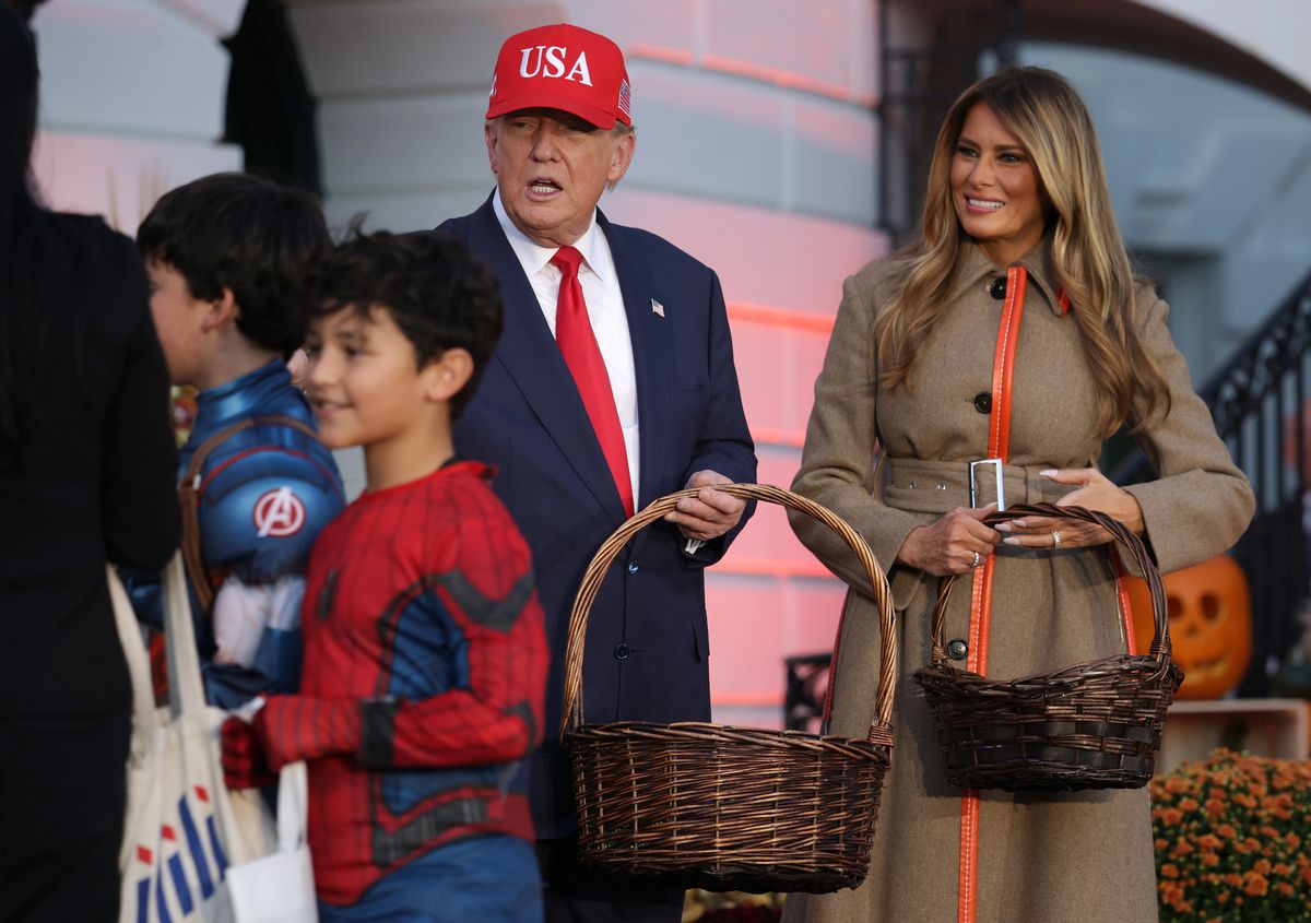 WASHINGTON, DC - OCTOBER 30: U.S. President Donald Trump and first lady Melania Trump handout candy to children during the annual Halloween at the White House event on the South Lawn of the White House on October 30, 2025 in Washington, DC. The President and first lady welcomed military, law enforcement, and foster and adoptive families, as well as administration officials and their children, to the annual trick-or-treat celebration on the White House grounds. (Photo by Alex Wong/Getty Images)