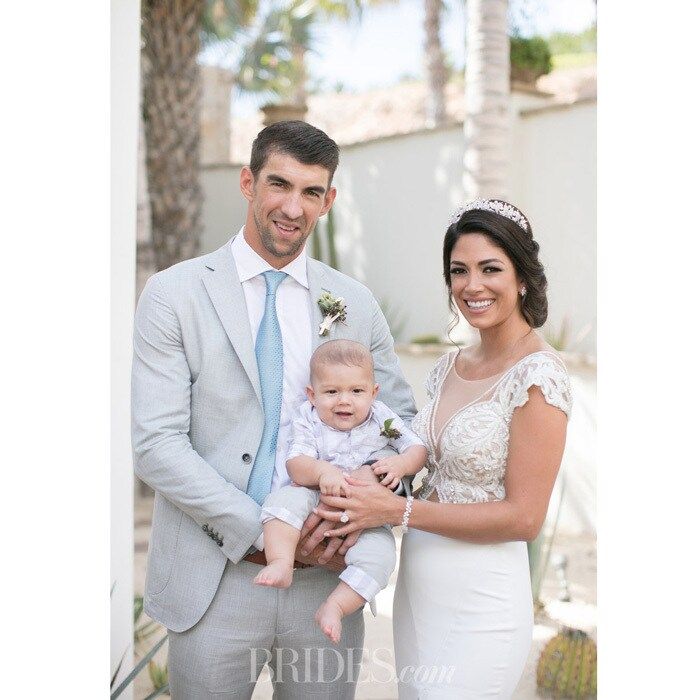 Boomer made one cute wedding party member! Michael Phelps' young son served as the adorable ring bearer at his parents's second nuptial in Cabo San Lucas, Mexico back in October. Discussing her son's role on her special day, Nicole Johnson told <a href="http://www.brides.com/story/michael-phelps-wedding-video">Brides magazine</a>, "We put [the ring] in one of those little net bags that you have for jewelry. We got one that matched his [Burberry] outfit, and we put that around his wrist, and he was carried down the aisle by [friend and gold-medal swimmer] Allison [Schmitt], our roommate. I think he kind of sucked on the bag a little bit while he was standing up there!"
Photo: Boone Studios via Brides.com