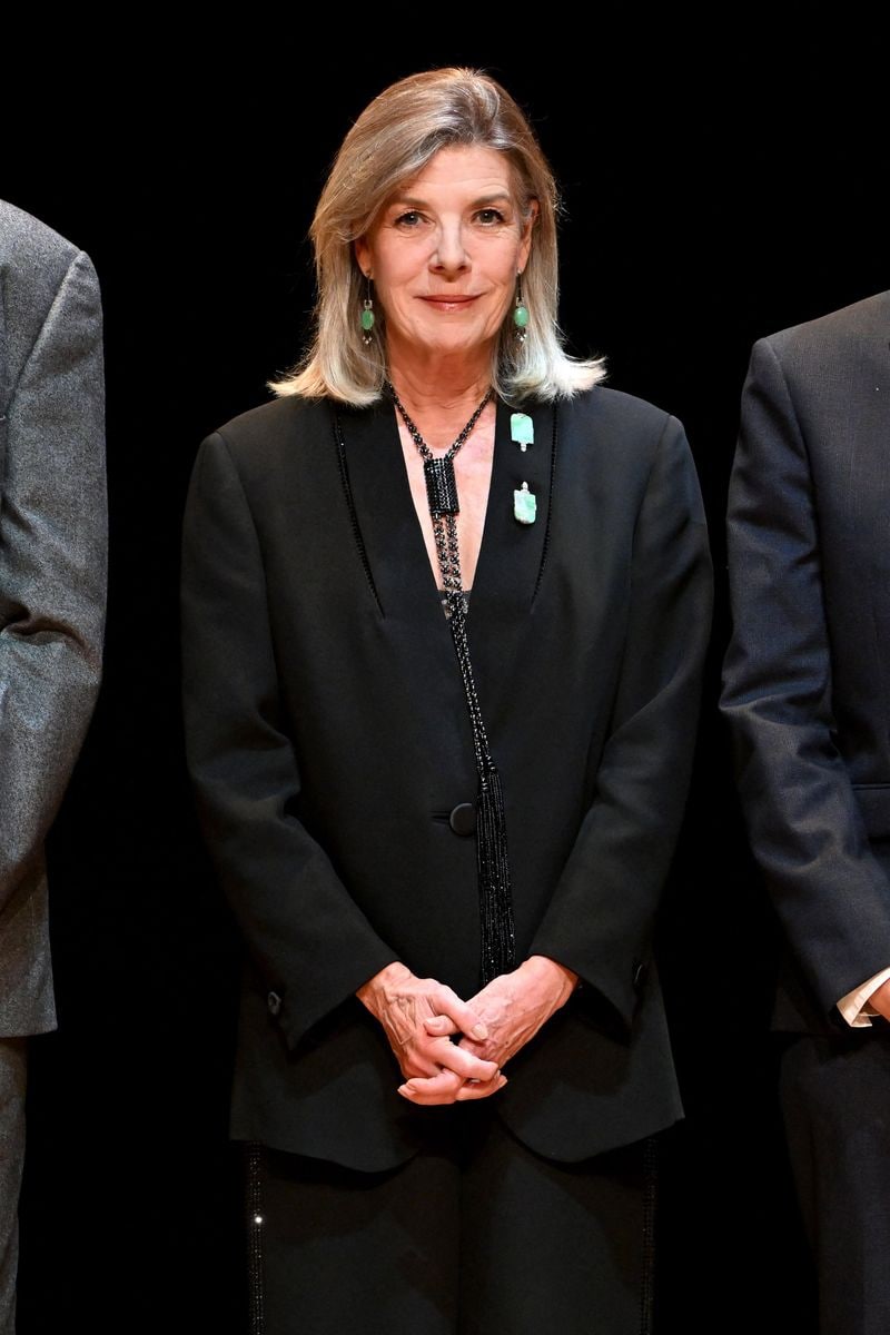 Caroline elevated her look with statement jewelry, including a long, tassel-adorned necklace cascading to her hip, paired with Art Deco-inspired earrings