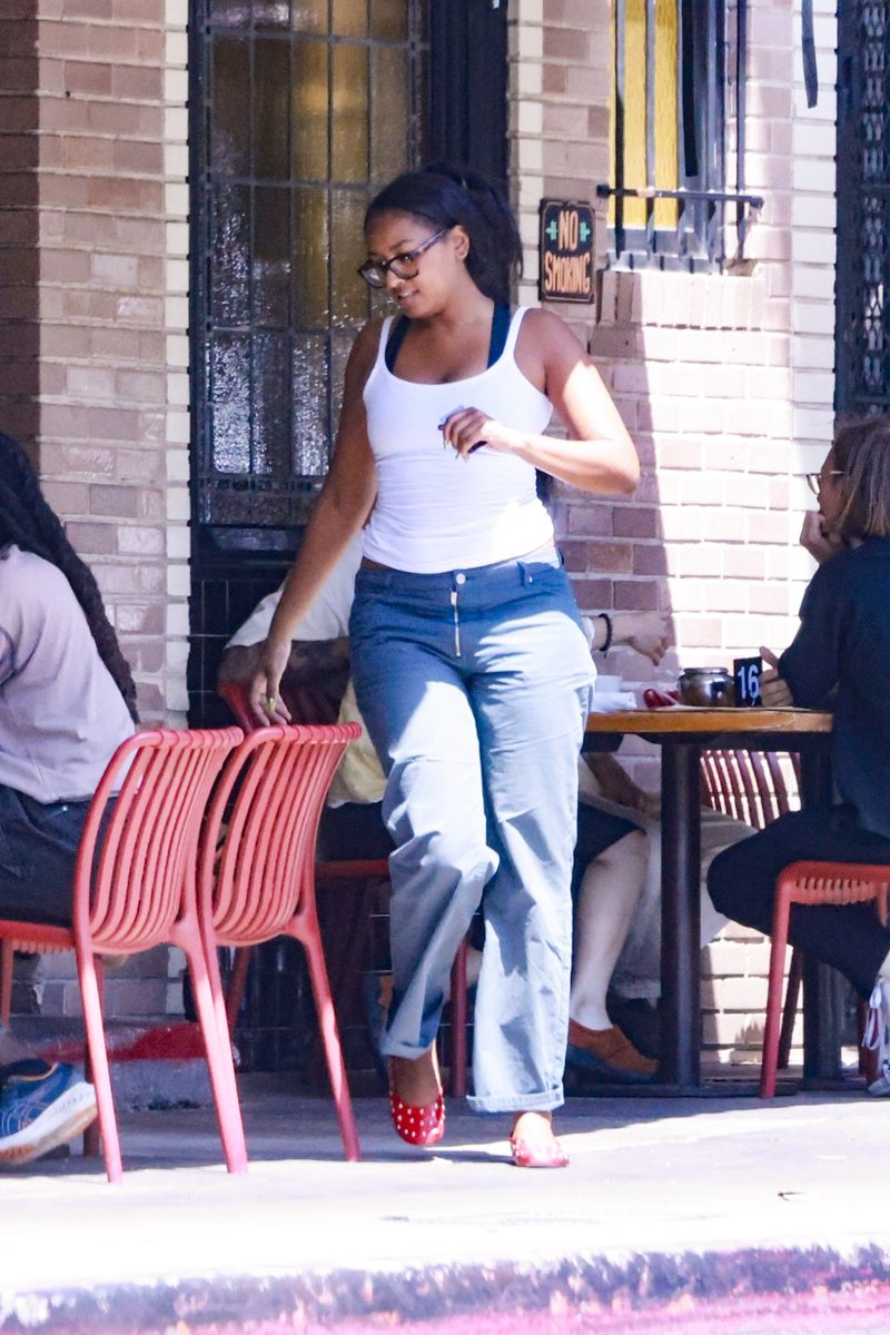 Sasha leaned into minimalist staples with a confident twist. She paired a fitted white tank top with mid-rise, slightly flared denim, an enduring silhouette that’s quietly reclaiming its place in modern wardrobes. 