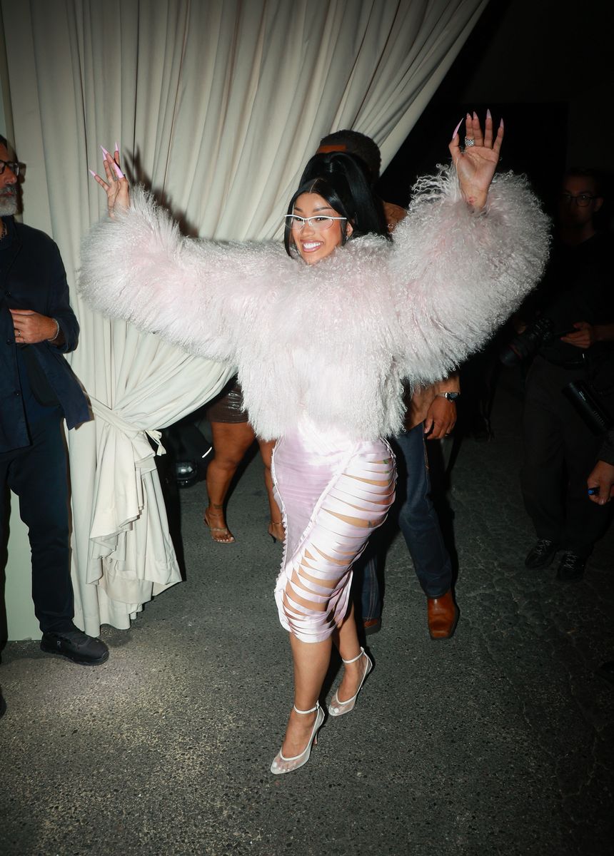 Cardi stepped out in Milan in a fluffy pale-pink jacket and daring cutout midi skirt, finishing the look with a sculptural updo and futuristic glasses.