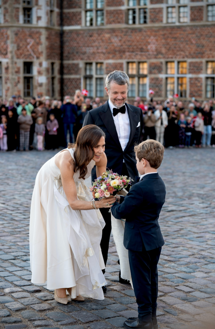 A sheer, gold-accented panel draped down the front of Mary’s dress, adding movement to its full skirt.