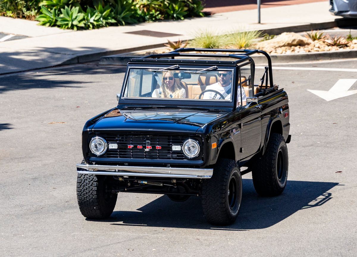 The couple held hands before cruising off together in a vintage Ford Bronco.