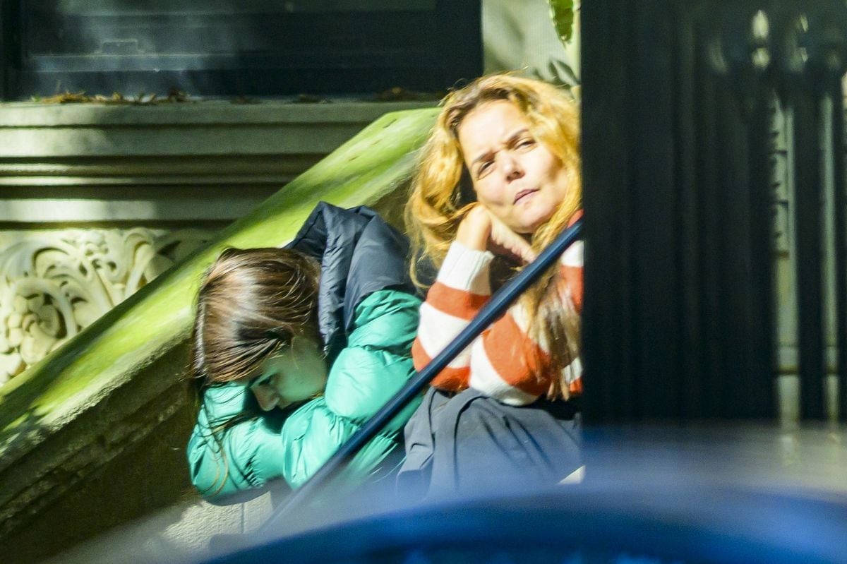 Suri Cruise and Katie Holmes sharing an emotional conversation on the stoop of a building