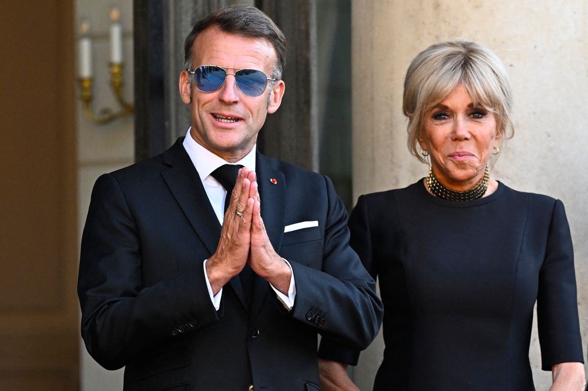 France's President Emmanuel Macron (L) getsures next to his wife Brigitte Macron at The Elysee Presidential Palace ahead of an official state dinner with South Africa's President and representatives in Paris on July 10, 2026. (Photo by JULIEN DE ROSA / AFP via Getty Images) 