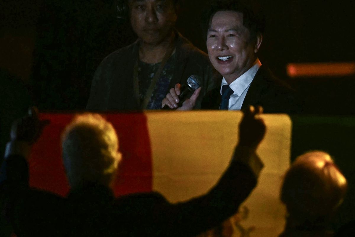 Miss Universe Thailand director Nawat Itsaragrisil (R) speaks in front of spectators holding a flag of Mexico ahead of the 2025 Miss Universe