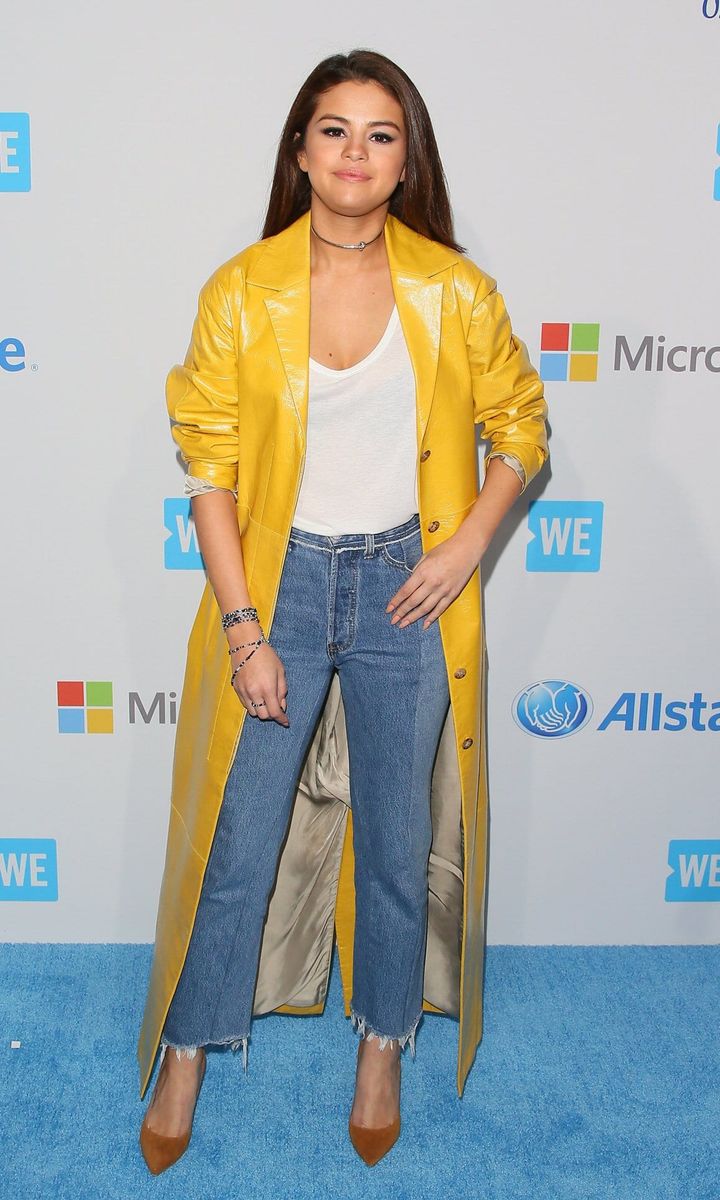 Selena Gomez wears jeans with a yellow coat