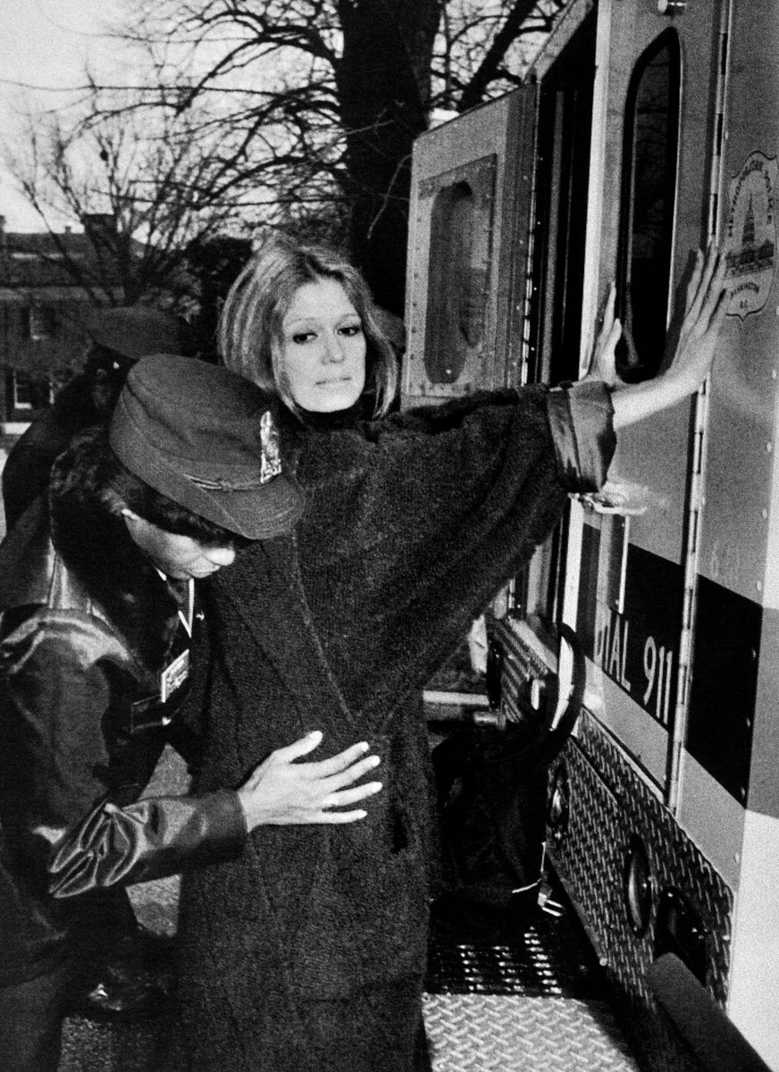 A US police officer arrests Women's rights activist Gloria Steinem during an anti-apartheid rally outside the South African Embassy in Washington