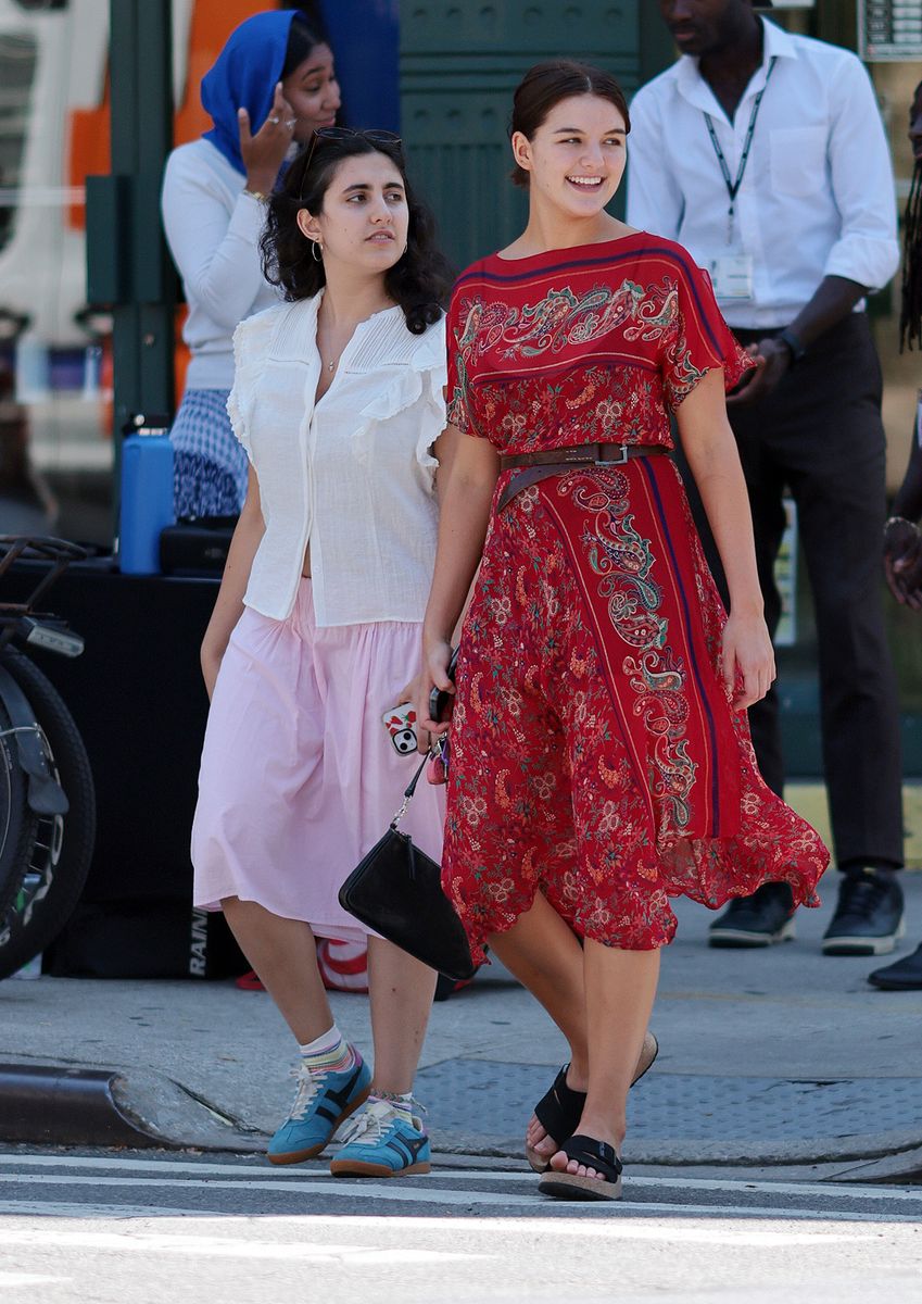  Suri Cruise was spotted stepping out for a juice wearing a red asymmetrical hem dress with a paisley print and short sleeves, cinched at the waist with a brown belt.