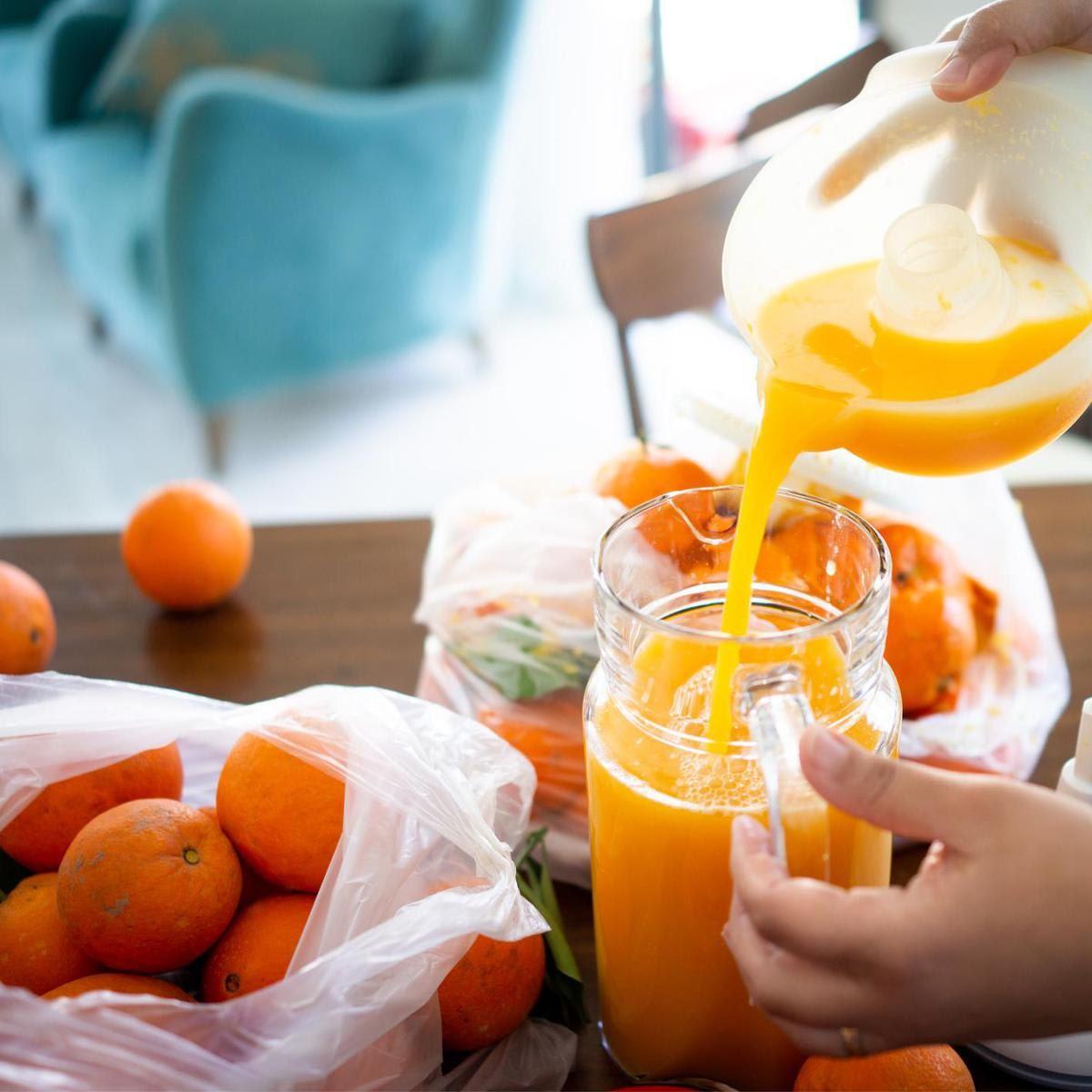 Child squeezing orange and making juice at home