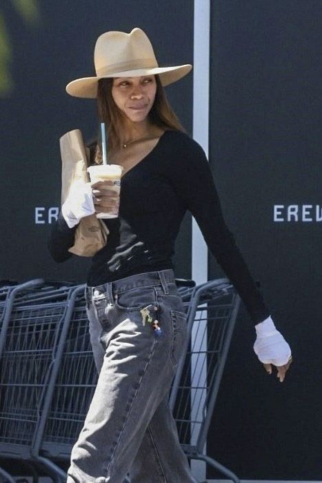 
Zoe Saldaña was spotted at Erewhon Market in Calabasas during a mid-morning stop, where she greeted staff and picked up a superfood smoothie. She wore a relaxed black long-sleeve top and grey straight-leg pants, complemented by white gloves and minimal accessories. The actress browsed the prepared foods section before placing her order at the trendy health store.
***
Zoe Saldaña fue vista en Erewhon Market en Calabasas durante una parada a media mañana, donde saludó al personal y recogió un smoothie de superalimentos. Llevaba una blusa negra de manga larga y pantalones grises rectos de corte relajado, combinados con guantes blancos y accesorios discretos. La actriz recorrió la sección de comidas preparadas antes de hacer su pedido en la conocida tienda de productos saludables.
