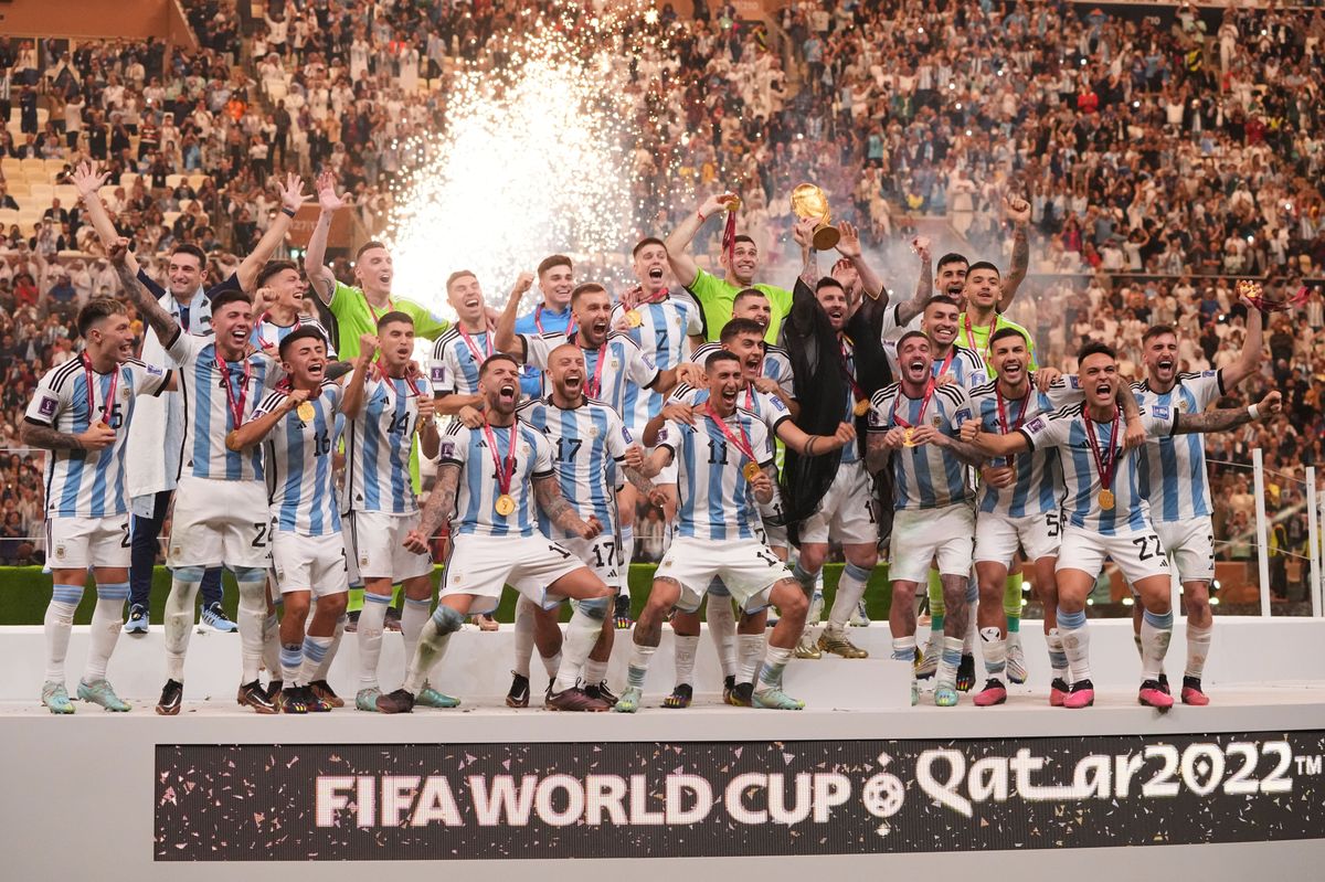 Lionel Messi of Argentina lifts the FIFA World Cup Trophy as he celebrates with team mates at their World Cup victory at Lusail Stadium on December 18, 2022 in Lusail City, Qatar.