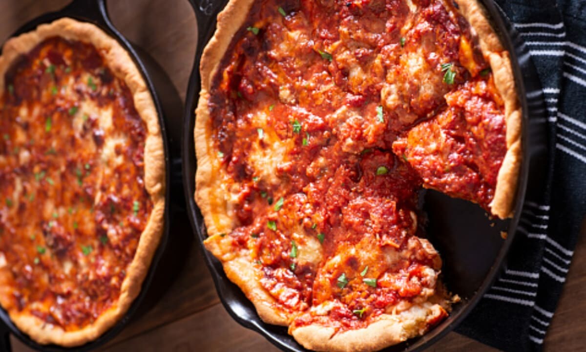 Deep Dish Pizza Chicago style, above with one cut out slice. On cutting board.