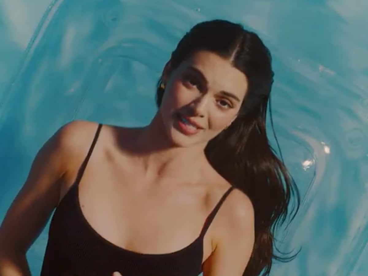 In one scene, Jenner lounges around a sprawling mansion and sunbathes poolside wearing a black high-cut one-piece swimsuit.