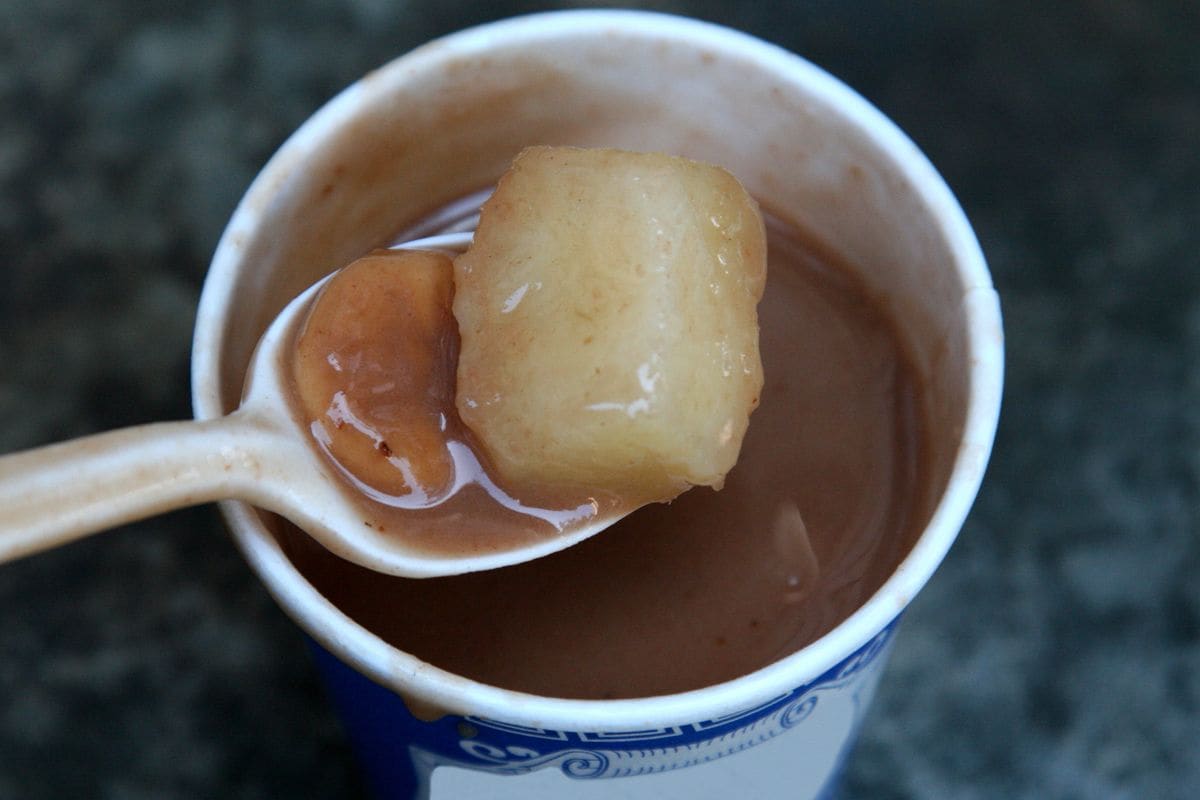 This dessert may surprise newcomers as it’s a sweet cream made from red beans blended with coconut milk, cinnamon, cloves, and sweet potatoes.