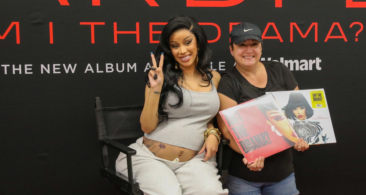 Cardi B poses with a fan at the "Am I The Drama" meet and greet at Walmart.