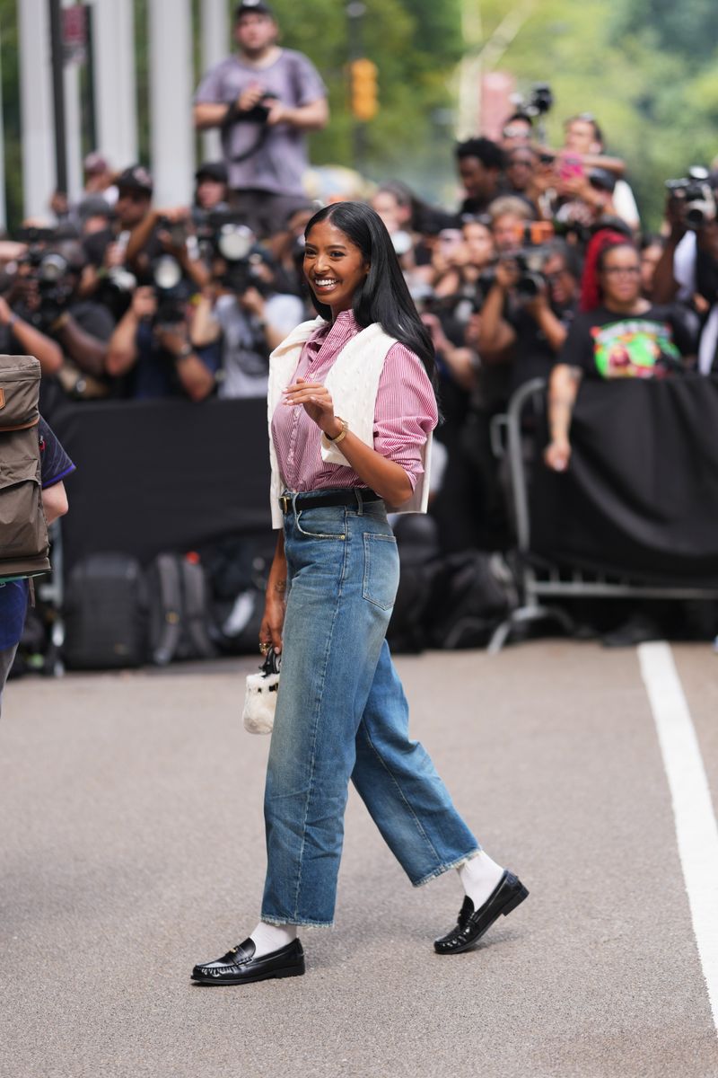Bryant paired black loafers with crisp white socks, giving an otherwise familiar jeans-and-shirt combination a deliberately styled finish.