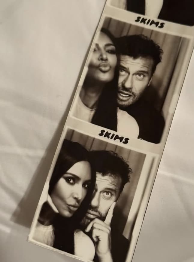 Kim Kardashian and a man snuggled up inside a photo booth