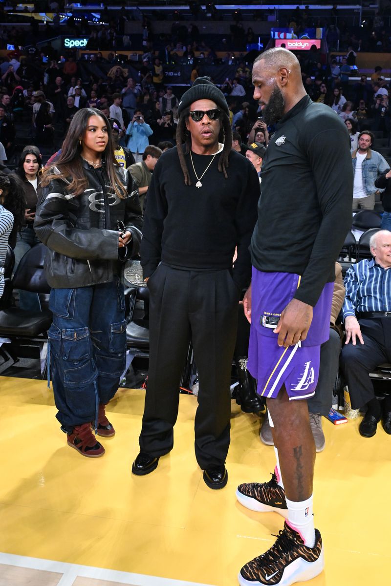 Jay-Z and Blue Ivy Carter talk to LeBron James following a basketball game.