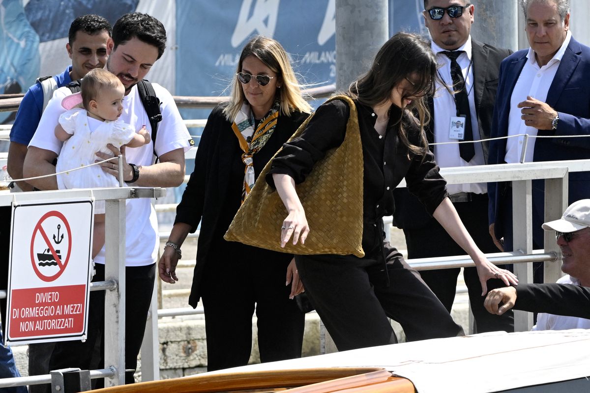 Jordan's Princess Rajwa (R), Crown Prince of Jordan, Hussein bin Abdullah and their daughter Iman Bint Hussein board a taxi boat after landing at Venice Marco Polo airport ahead of Jeff Bezos' wedding on June 26, 2025. Celebrities in superyachts sail into Venice this week for the three-day wedding party of Amazon tycoon Jeff Bezos and Lauren Sanchez, despite irate locals who say the UNESCO city is no billionaire's playground. The tech magnate and journalist have reportedly invited about 200 guests to their multi-million dollar nuptials in the Italian city, which are expected to kick off on June 26 and end Saturday with a ceremony at a secret location. (Photo by ANDREA PATTARO / AFP) (Photo by ANDREA PATTARO/AFP via Getty Images)          