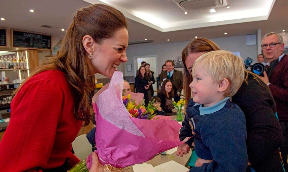 Kate Middleton in red dress meeting boy