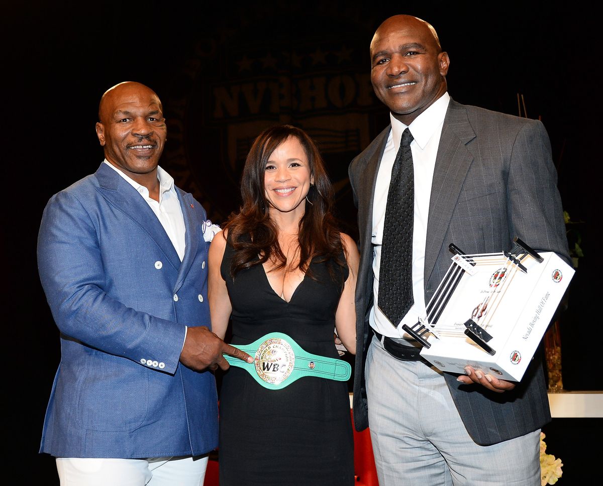  (L-R) Former boxer Mike Tyson, actress and emcee Rosie Perez and former boxer Evander Holyfield pose onstage after Tyson inducted Holyfield into the Nevada Boxing Hall of Fame at the second annual induction gala at the New Tropicana Las Vegas on August 9, 2014 in Las Vegas, Nevada.  (Photo by Ethan Miller/Getty Images)