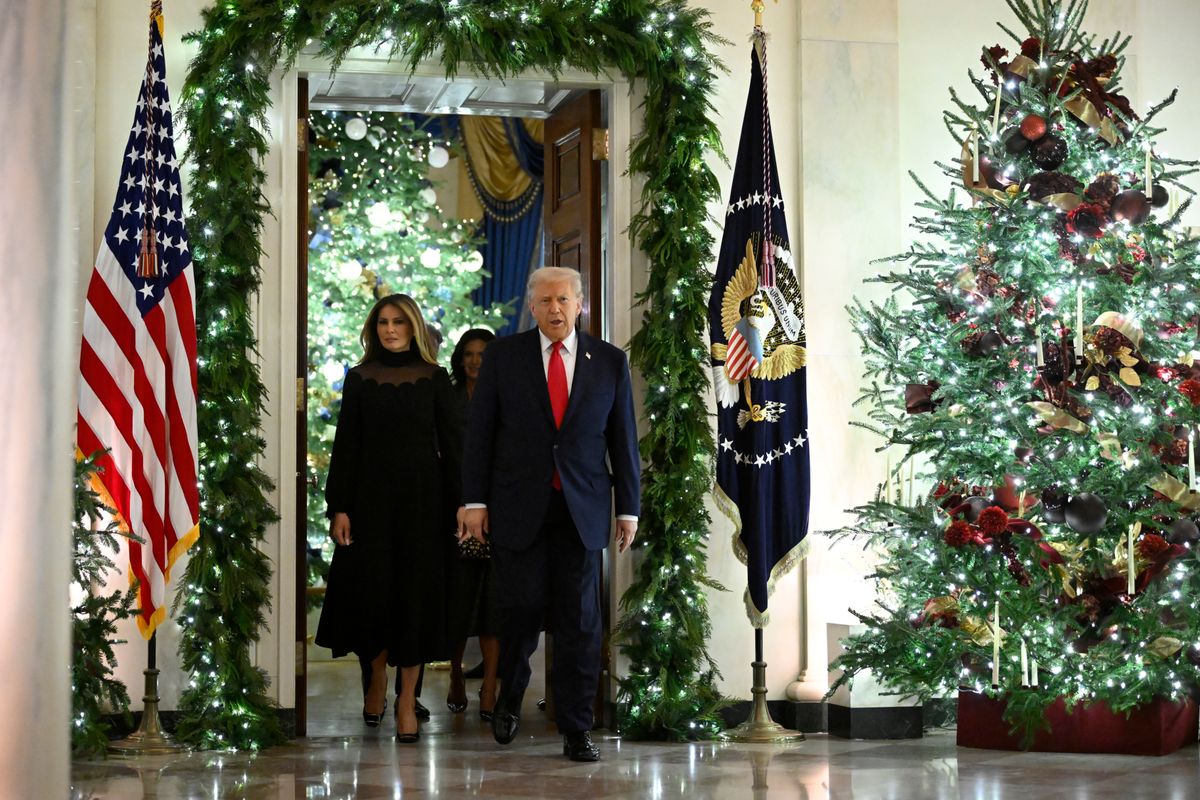 President Donald Trump and first lady Melania walk among Christmas decorations.