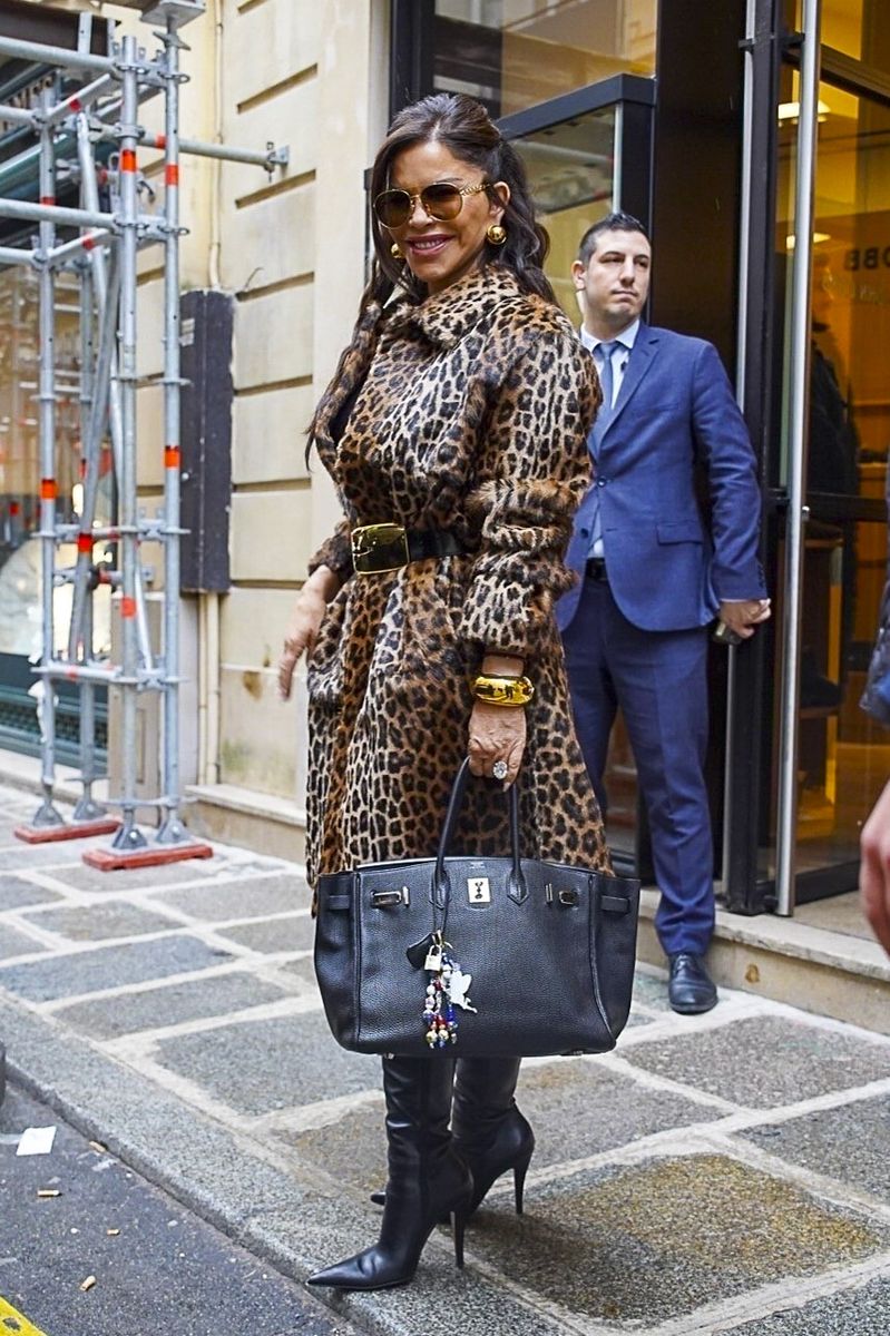  Lauren Sanchez Bezos was spotted walking out of a Hermès store during Paris Fashion Week. She wore a leopard-print faux fur coat cinched with a wide black belt featuring a gold buckle over a black top. 