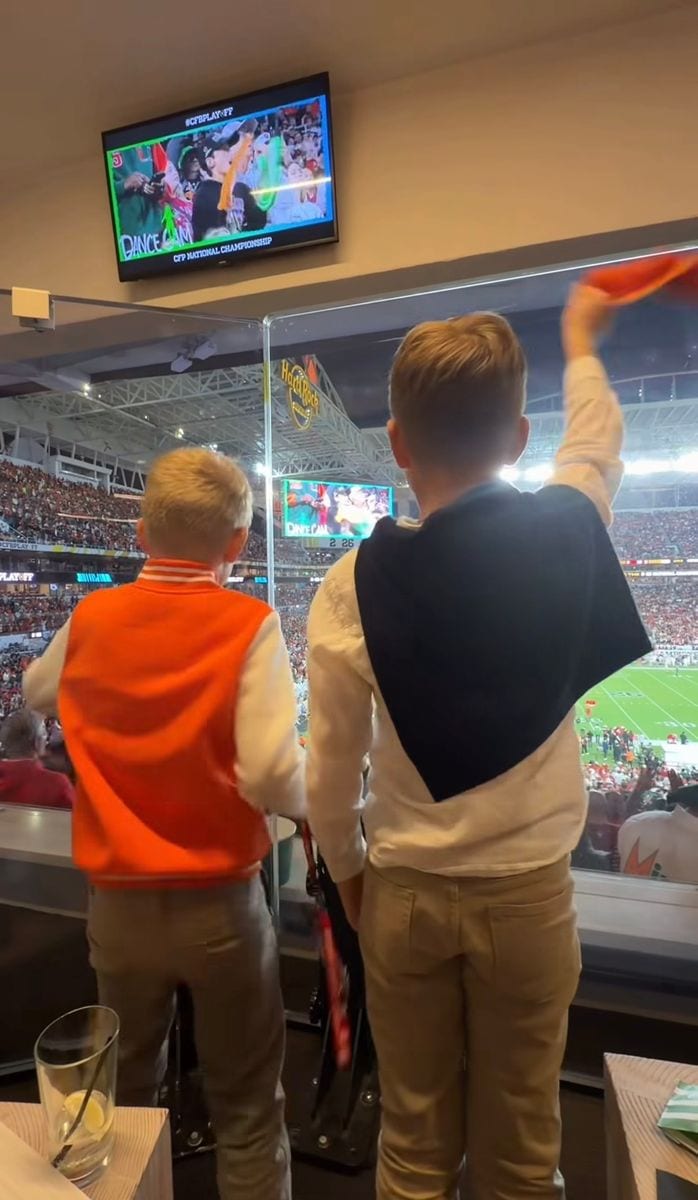 Standing beside her, Ivanka’s son coordinated effortlessly, wearing a white button down shirt layered with a navy sweater draped neatly over his shoulders.